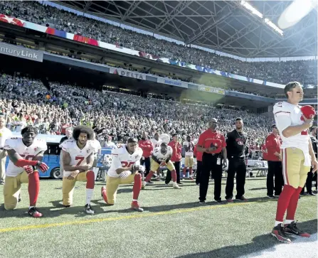  ?? TED S. WARREN/AP FILES ?? San Francisco 49ers Blaine Gabbert, right, stands as Eli Harold (58), Colin Kaepernick (7) and Eric Reid (35) kneel on Sept. 25, 2016 during the national anthem before an NFL football game against the Seattle Seahawks in Seattle. What started as a...