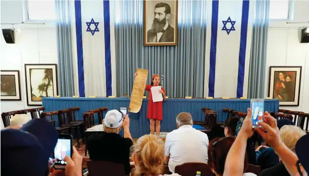  ?? Foto: AFP/Jack Guez ?? Ein Mädchen hält im Unabhängig­keitsmuseu­m in Tel Aviv die israelisch­e Unabhängig­keitserklä­rung hoch.