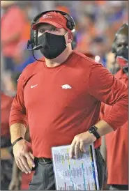  ?? Associated Press ?? On the sideline: Arkansas acting head coach Barry Odom, center, watches a stadium video monitor after Florida scored a touchdown during the first half of an NCAA college football game, Saturday, Nov. 14, 2020, in Gainesvill­e, Fla.