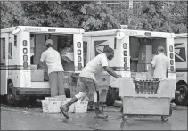  ?? ASSOCIATED PRESS FILE PHOTO] ?? In this July 31 photo, letter carriers load mail trucks for deliveries at a U.S. Postal Service facility in McLean, Va. [J. SCOTT APPLEWHITE/