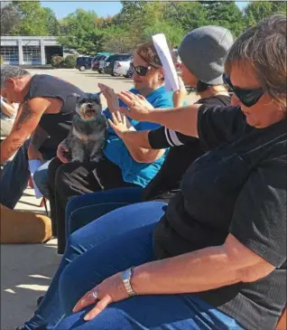  ?? TRACEY READ — THE NEWS-HERALD ?? Crackers, a 12-year-old miniature schnauzer, receives a blessing Oct. 14 outside DeJohn Funeral Homes &amp; Crematory in Willoughby Hills. Holding Crackers is Willoughby resident Alicia Garbo. Also pictured are Garbo’s daughter, Allison, and sister, Paula.