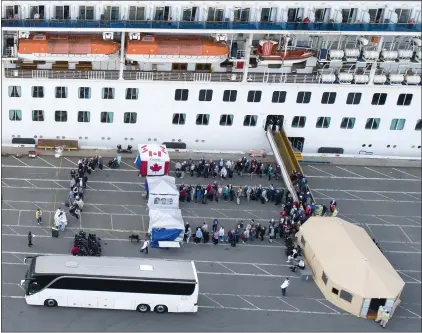  ?? JANE TYSKA — STAFF PHOTOGRAPH­ER ?? Passengers disembark from the Grand Princess cruise ship while docked at the Port of Oakland on Monday. The coronaviru­s-stricken ship arrived at the port after remaining in a holding pattern outside the Golden Gate for several days.