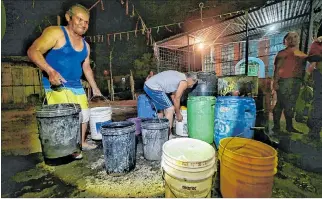  ?? ALEJANDRO GILER / EXPRESO ?? Manta. Vecinos de la ciudad portuaria manabita recogen agua en baldes ante la crisis de desabastec­imiento.