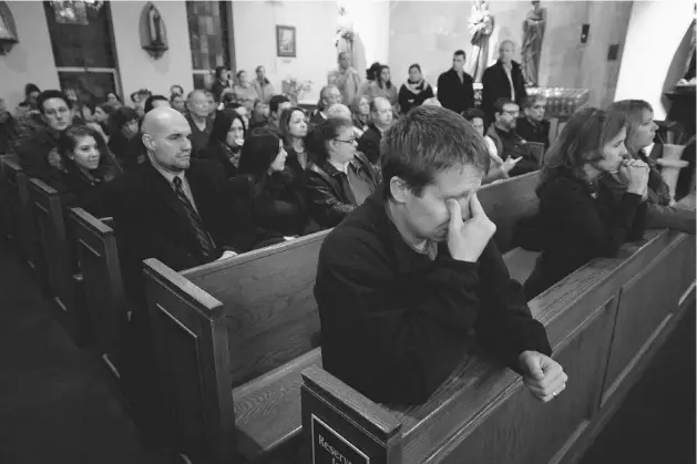  ?? Andrew Gombert/getty Images ?? Mourners gather inside St. Rose of Lima Roman Catholic Church at a vigil service for victims of the Sandy Hook School shooting Friday in Newtown, Conn.