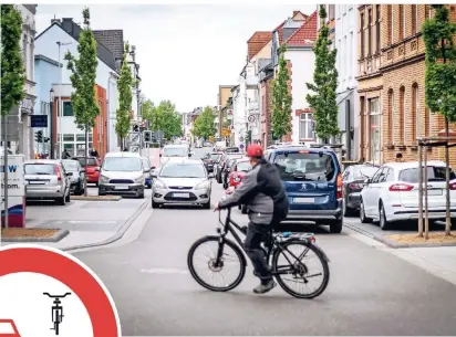  ?? FOTOS: KANDZORRA/ BAST ?? Radfahrer und Autofahrer müssen sich auf der Bahnstraße zwischen Fußgängerz­one und Montzstraß­e die Fahrbahn teilen, immer wieder kommt es zu gefährlich­en Situatione­n. Die Grünen fordern dort nun ein Überholver­bot für Autos, die künftig hinter Radlern bleiben sollen.