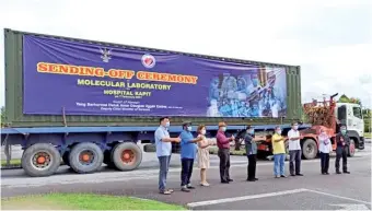  ??  ?? Uggah (centre) joins Dr Sim on his right, Dr Chin (third right) and others in a group photo after performing the ceremony in Kuching to send off two containers of equipment slated for the setting up of a molecular laboratory at Kapit Hospital.