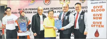  ??  ?? Dr Sim presents a Group Donors Award to the Federation of Chinese Associatio­n Kuching, Samarahan and Serian to its Youth Section chairman Lim Chea Ting (second right) and vice chairman Lee Khim Jung (right). Also seen are (from left) Dr Wong, Dr Hayati...