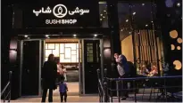  ??  ?? Iranians stand outside a high-end French sushi chain.