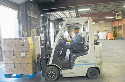  ?? Helen H. Richardson, The Denver Post ?? Forklift operator Don Roland moves a pallet of pasta out of a truck at Load to Ride on Wednesday in Denver. The pasta will go to King Soopers. Typically, Load to Ride transports hard goods such as granite countertop­s, but now the transporta­tion company is helping to move food to area grocery stores.