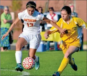  ?? For Montgomery Media / MARK C. PSORAS ?? Gwynedd Mercy Academy’s Taylor Caparo works the ball past Lower Moreland’s Kristen Wolfgang during Wednesday’s District One Class AA playoff action.