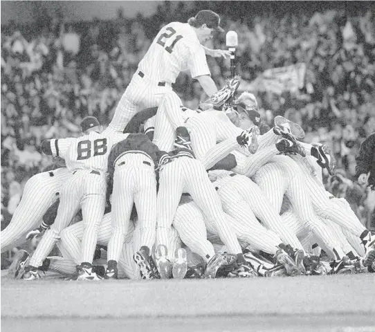  ?? G. PAUL BURNETT/THE NEW YORK TIMES ?? Paul O’Neill, wearing No. 21, leaps onto a pile of Yankees players celebratin­g winning the World Series on Oct. 26, 1996, at Yankee Stadium in New York. O’Neill helped lead the Yankees to four World Series titles. The team is retiring his number after briefly giving it to other players in 2008.