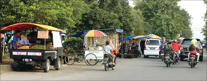  ?? BOY SLAMET/JAWA POS ?? BAKAL DIREVITALI­SASI: Meski sudah mendapat peringatan, beberapa pedagang tetap berjualan di jalan dan trotoar di kawasan Perumahan Gading Fajar.