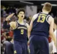  ?? MICHAEL CONROY — THE ASSOCIATED PRESS ?? Michigan’s Moritz Wagner (13) and D.J. Wilson celebrate their 73-69 win over Louisville on Sunday.