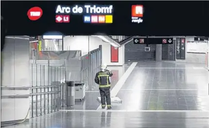  ?? XAVIER GÓMEZ ?? Trabajando a oscuras. Un mando de los bomberos, en el vestíbulo de Arc de Triomf, mientras los servicios de extinción trataban de dar con las llamas desde los túneles de esa estación