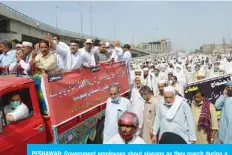  ?? —AFP ?? PESHAWAR: Government employees shout slogans as they march during a protest against government’s fiscal budget for 2020-21, in Peshawar demanding an increase in salary.