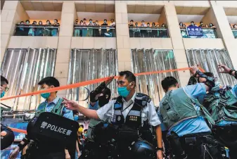  ?? Anthony Wallace / AFP via Getty Images ?? Police enter a shopping mall to disperse people attending a lunchtime rally in Hong Kong after China passed a sweeping national security law that critics fear will smother the city’s freedoms.