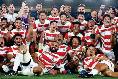 ?? GETTY IMAGES ?? Job done: Japan’s jubilant players celebrate reaching the quarter-finals