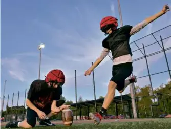  ?? JOSH REYNOLDS FOR THE GLOBE ?? With the help of holder Connor Pandolph, Winchester senior kicker Kieran Corr, bound for Harvard, stays sharp with repeated repetition­s in practice.