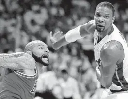  ?? MICHAEL LAUGHLIN/STAFF PHOTOGRAPH­ER ?? Heat forward Chris Bosh, right, is called for a foul for pushing Chicago’s Carlos Boozer during the second quarter of Game 2