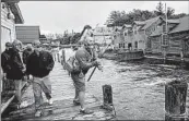  ?? ZBIGNIEW BZDAK/CHICAGO TRIBUNE ?? Visitors enjoy fishing for salmon at Fishtown in Leland, Michigan on Oct. 1.