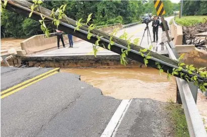  ?? JEFF BILL/BALTIMORE SUN ?? Rain that continued to cause problems across Central Maryland on Monday washed out part of a bridge on Route 198 in Laurel.