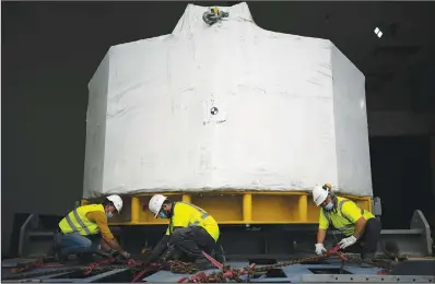  ??  ?? Workers receive the central solenoid magnet for the ITER project.