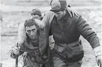  ?? ?? A United Nations soldier helps a wounded Canadian rifleman to an aid station behind the front lines during the Korean War in 1950