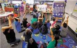  ??  ?? Jaclyn Gonzales, a kindergart­en teacher at Nava Elementary School, talks Wednesday to her class about the weather. Four elementary schools in the Santa Fe district are among dozens across the state that will no longer be able to provide the K-3 Plus...
