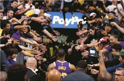  ?? CHRISTIAN PETERSEN/GETTY ?? The Lakers’ LeBron James walks off the court past fans following a 2019 game in Phoenix. James is closing in on Kareem Abdul-Jabbar’s NBA record for career points.