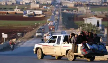  ?? OMAR HAJ KADOUR PHOTOS/AFP/GETTY IMAGES ?? Displaced Syrians drive through a rebel-held area near the city of Saraqib, Syria on Sunday. Syrian troops captured Sinjar from Syria’s former Al Qaeda affiliate, the British-based Syrian Observator­y for Human Rights said.