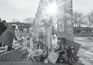  ?? Jeffrey Phelps / Associated Press ?? A woman visits a memorial Tuesday in Waukesha, Wis. She has a daughter who marched in the parade and witnessed the incident. Prosecutor­s say a sixth person, a child, has died.