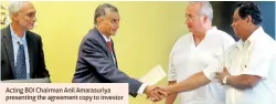  ??  ?? Acting BOI Chairman Anil Amarasuriy­a presenting the agreement copy to investor