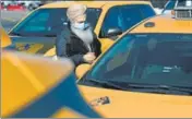  ?? AFP ?? A yellow cab taxi driver cleans his car as he waits in line at a taxi hold at LaGuardia Airport in New York City.