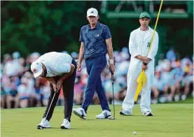  ?? David J. Phillip/associated Press ?? Defending champion Jon Rahm, left, got off to a slow start in his opening round, with three birdies and three bogeys across his first 14 holes.