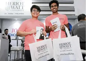  ??  ?? (From left) Aldiniy and Sanjit Kumar shared informatio­n about their university with visitors.