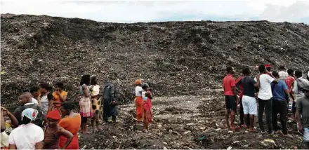 ?? Celso Baife/Xinhua ?? Moradores observam resgate de soterrados após desmoronam­ento de um depósito de lixo de Maputo, em Moçambique