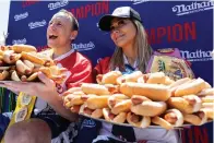  ?? The Associated Press ?? ■ Joey Chestnut and Miki Sudo pose with 63 and 40 hot dogs, respective­ly, after winning the Nathan’s Famous Fourth of July hot dog eating contest in Coney Island on Monday in New York.