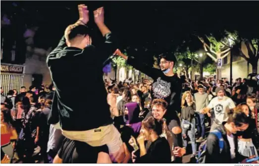  ?? QUIQUE GARCÍA / EFE ?? Decenas de jóvenes celebran junto al Passeig de Lluis Companys de Barcelona, el fin del estado de alarma.