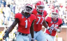  ?? KEN WARD/GEORGIA PHOTO ?? Georgia tailback Sony Michel (1), offensive lineman Isaiah Wynn (77) and fullback Christian Payne (47) celebrate during the 13-7 win at Georgia Tech in 2015.