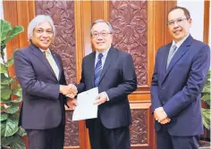  ??  ?? Bank Negara Governor Tan Sri Muhammad Ibrahim (left) presenting the appointmen­t letter to Mah (middle) as the new director-general of Labuan FSA yesterday. Also present is Ahmad Hizzad. — Bernama photo