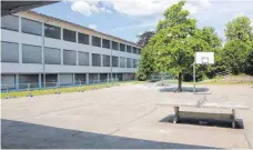  ?? FOTO: MARKUS DREHER ?? Der Pausenhof der Grundschul­e in Ummendorf soll zeitgemäße­r gestaltet werden. Halb durch den Baum verdeckt ist das Kletterger­üst zu erkennen. Entlang des Gebäudes sperrt ein Bauzaun den Rasen ab.