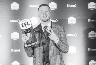  ?? JASON FRANSON THE CANADIAN PRESS ?? Calgary Stampeders quarterbac­k Bo Levi Mitchell holds his award as CFL’s most outstandin­g player in Edmonton on Thursday.