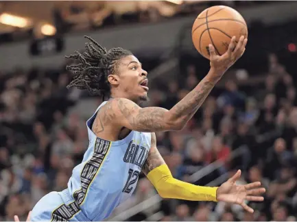  ?? ANDY CLAYTON-KING/AP ?? Memphis Grizzlies guard Ja Morant grabs the ball against the Minnesota Timberwolv­es in the second quarter of a game on Wednesday in Minneapoli­s.