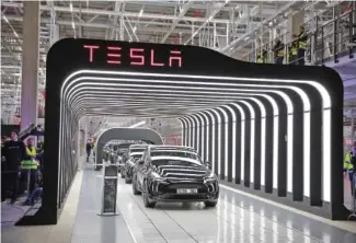  ?? CHRISTIAN MARQUARDT/GETTY IMAGES/TNS ?? Newly completed Tesla electric cars are seen at the official opening of the Tesla electric car manufactur­ing plant in 2022 near Gruenheide, Germany.