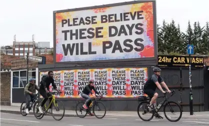  ??  ?? Cyclists pass an encouragin­g billboard in east London - but there have been suggestion­s the UK could be paying off its coronaviru­s debt for 50 years Photograph: REX/Shuttersto­ck