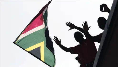  ?? PHOTO: REUTERS ?? In this file photo, a man waves a South African flag after the death of former President Nelson Mandela. The country has come a long way from the moral high ground it enjoyed, says the writer.