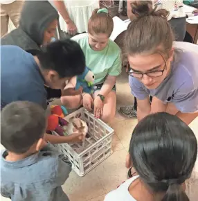  ?? CATHOLIC CHARITIES OF WEST TENNESSEE ?? St. Agnes Academy students Gracie Fogerty and Madelynn Fay play with toddlers at the Humanitari­an Respite Center in McAllen, Texas, which is run by Catholic Charities of the Rio Grande Valley.