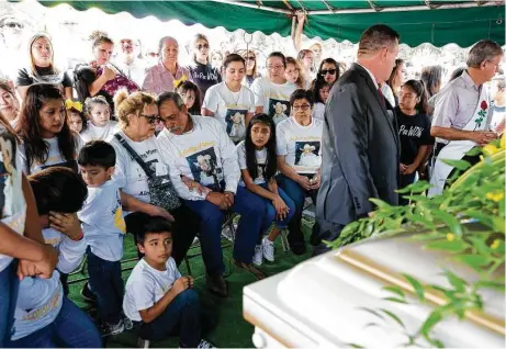  ?? Fotos de Godofredo A. Vásquez / Houston Chronicle ?? Parientes y amigos de Alonso Guillén, con una camisa en su memoria, durante el funeral el sábado en el cementerio Whitehouse.