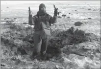  ?? INNA VARENYTSIA, THE ASSOCIATED PRESS ?? A Ukrainian soldier shows pieces of shrapnel in a crater left by an explosion in Avdiivka, Ukraine in January this year.