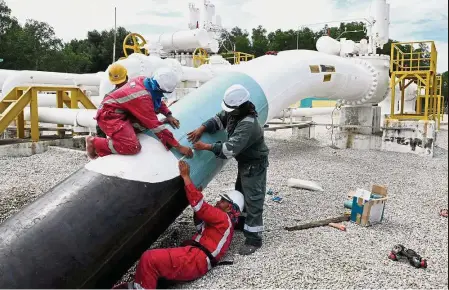  ?? — Bernama ?? Tariff up: Contract workers patching up a gas pipe at the Kapar Petronas metering station. From next year, the effective gas tariff rate will be increased by an average of 16%.